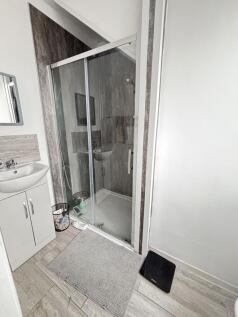 A modern bathroom featuring a spacious shower e...