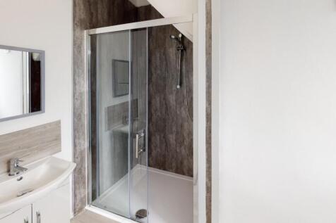 A modern bathroom featuring a spacious shower e...