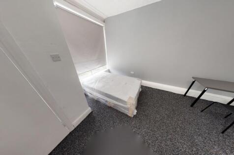 A clean, minimalistic bedroom with a single bed...