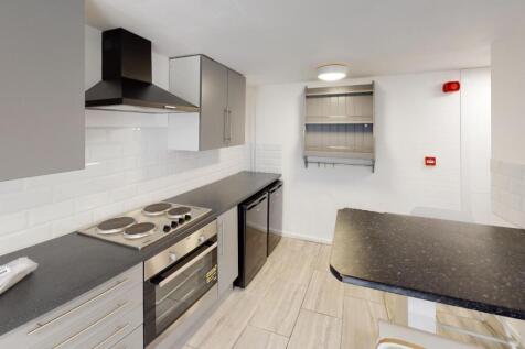 Modern fitted kitchen with integrated oven and ...