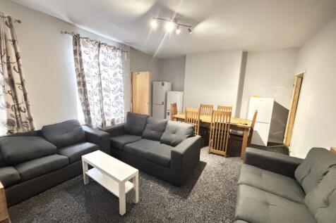 A spacious and well-lit living room featuring a...