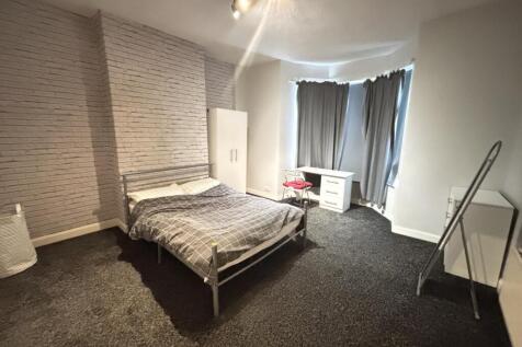 A spacious bedroom featuring a double bed, larg...
