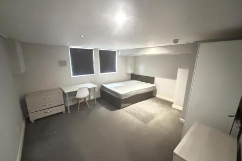 A bright and tidy bedroom featuring a comfortab...