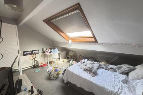 A cozy bedroom with a neatly made bed situated ...