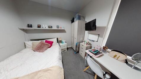 A cozy single bedroom featuring a comfortable b...