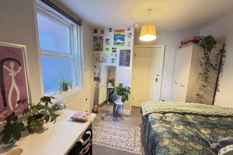 A spacious and well-lit bedroom featuring a lar...