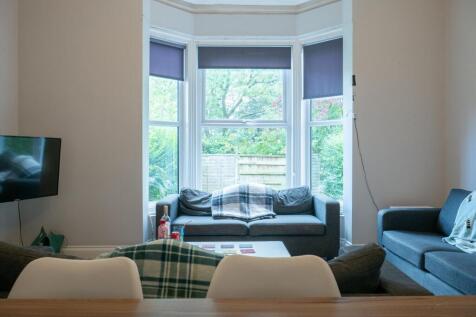 A well-lit and inviting living room featuring a...