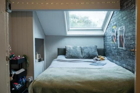 A cozy bedroom featuring a double bed under a s...