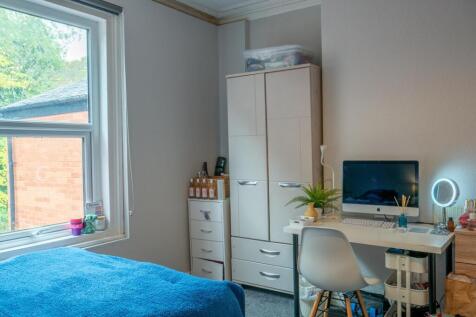 A bright and tidy bedroom featuring a comfortab...