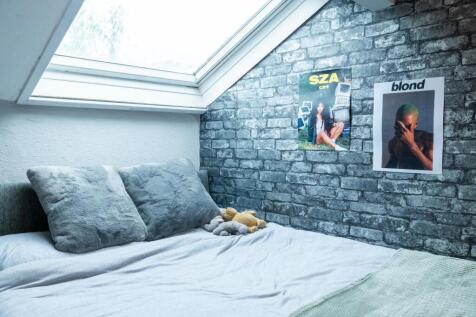 A cozy bedroom featuring a neatly made bed with...