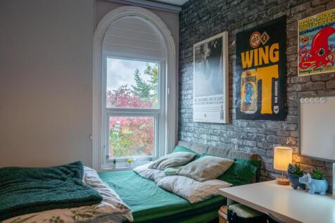 A cozy bedroom featuring a large window that pr...