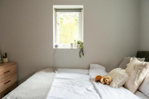 A bright and welcoming master bedroom featuring...