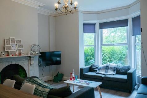 Bright and spacious living room featuring large...