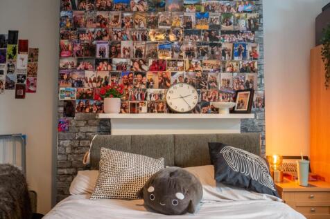 A cozy bedroom featuring a bed with decorative ...