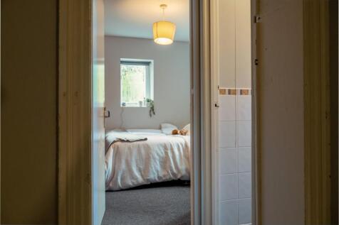 A bright and tidy bedroom featuring a comfortab...