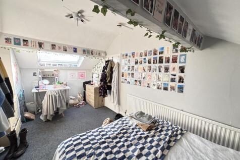 A bright and tidy student bedroom with a comfor...