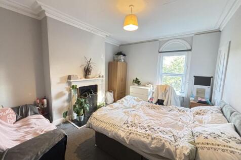 A bright and welcoming bedroom featuring a comf...