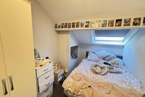 A spacious and well-lit bedroom featuring a lar...