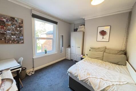 A well-maintained bedroom featuring a comfortab...