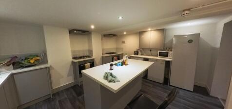 A modern, well-lit kitchen featuring a large ce...