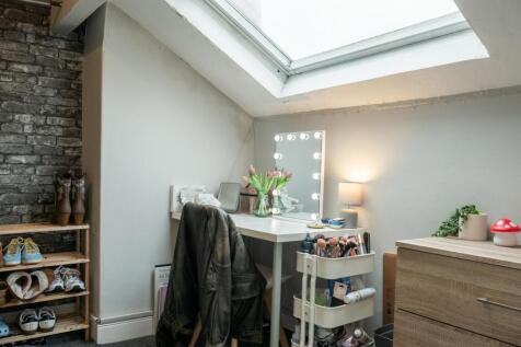 A bright and tidy bedroom featuring a large sky...
