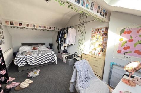 A cozy and bright bedroom with a comfortable be...