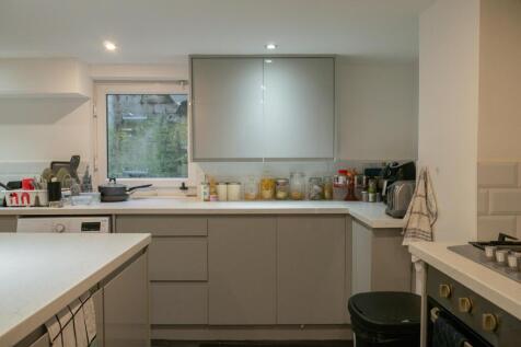A modern, well-lit kitchen featuring ample coun...