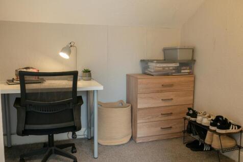 A compact study area featuring a desk with a ch...