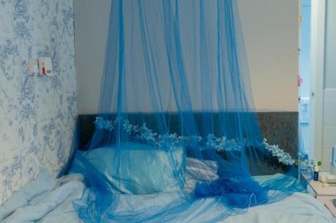 A cozy bedroom featuring a double bed with blue...