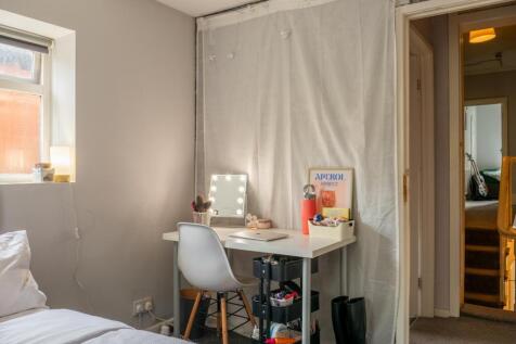 A compact bathroom with basic fixtures, featuri...