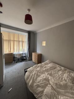 A cozy bedroom with a large window providing pl...