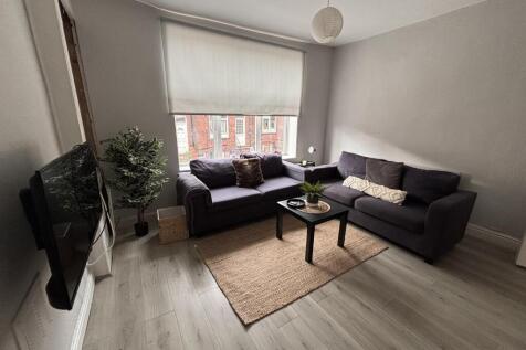 Bright and spacious living room featuring large...