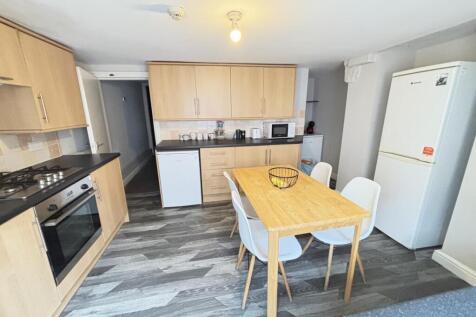 A bright and modern kitchen featuring wooden ca...