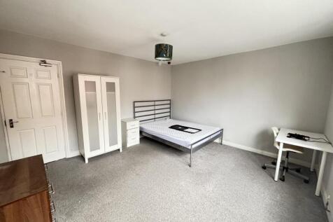 A clean, well-lit bedroom with ample space, fea...