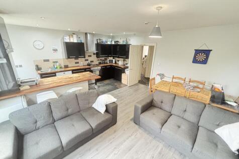 A spacious and modern living room featuring com...