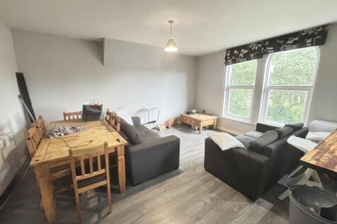 A bright and spacious living room featuring lar...