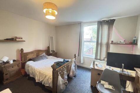 A cozy single bedroom with a comfortable bed, a...