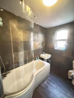 A spacious bathroom featuring a large bathtub, ...