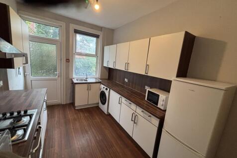 A well-maintained kitchen featuring white cabin...