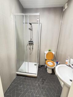 A clean and modern bathroom featuring a corner ...