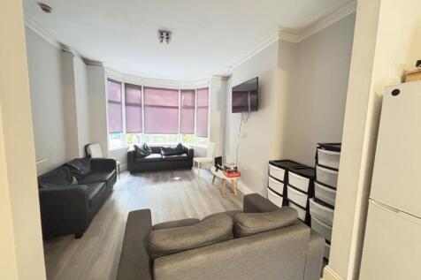 A spacious and well-lit living room with comfor...