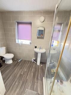A bright and clean bathroom featuring a shower ...