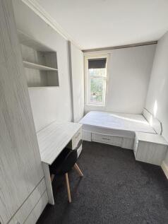 A bright and tidy small bedroom featuring a sin...