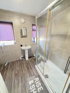 A modern bathroom featuring a large shower encl...
