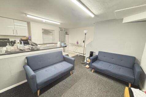 A spacious and modern living room featuring two...