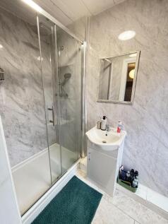 A modern bathroom featuring a spacious shower e...