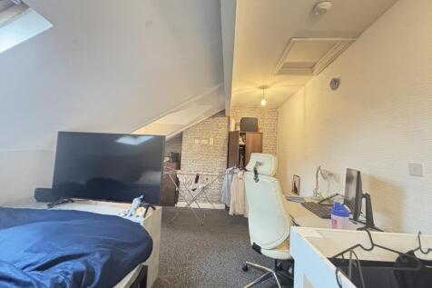 A cozy student bedroom featuring a single bed, ...