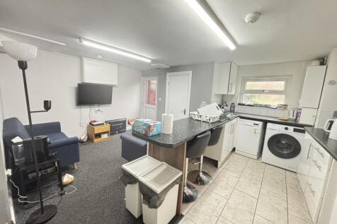A bright and modern kitchen area featuring a wa...