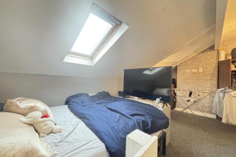 A cozy bedroom featuring a bed with a dark blue...