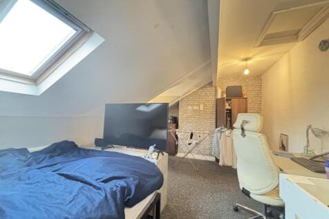 A well-lit bedroom featuring a comfortable bed,...